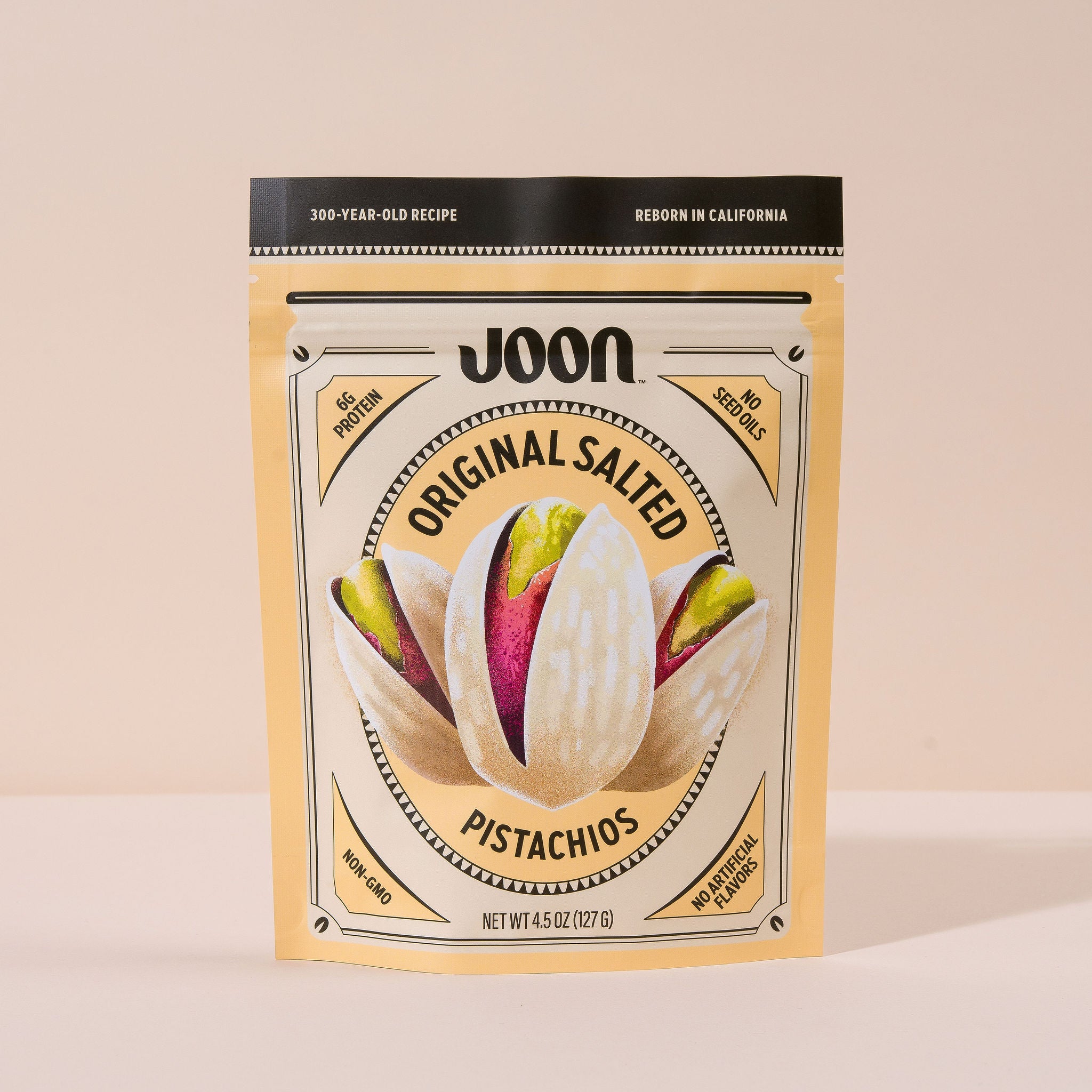 A package of Joon Original Salted Pistachios showing the product through a clear window, with a beige background.